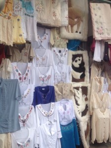 Embroidered shirts and alpaca wool mats at a craft market