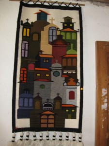 Woven wall hanging depicting Quito with its many churches