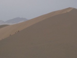 People climbing the dune to watch the sunset and sandboard down